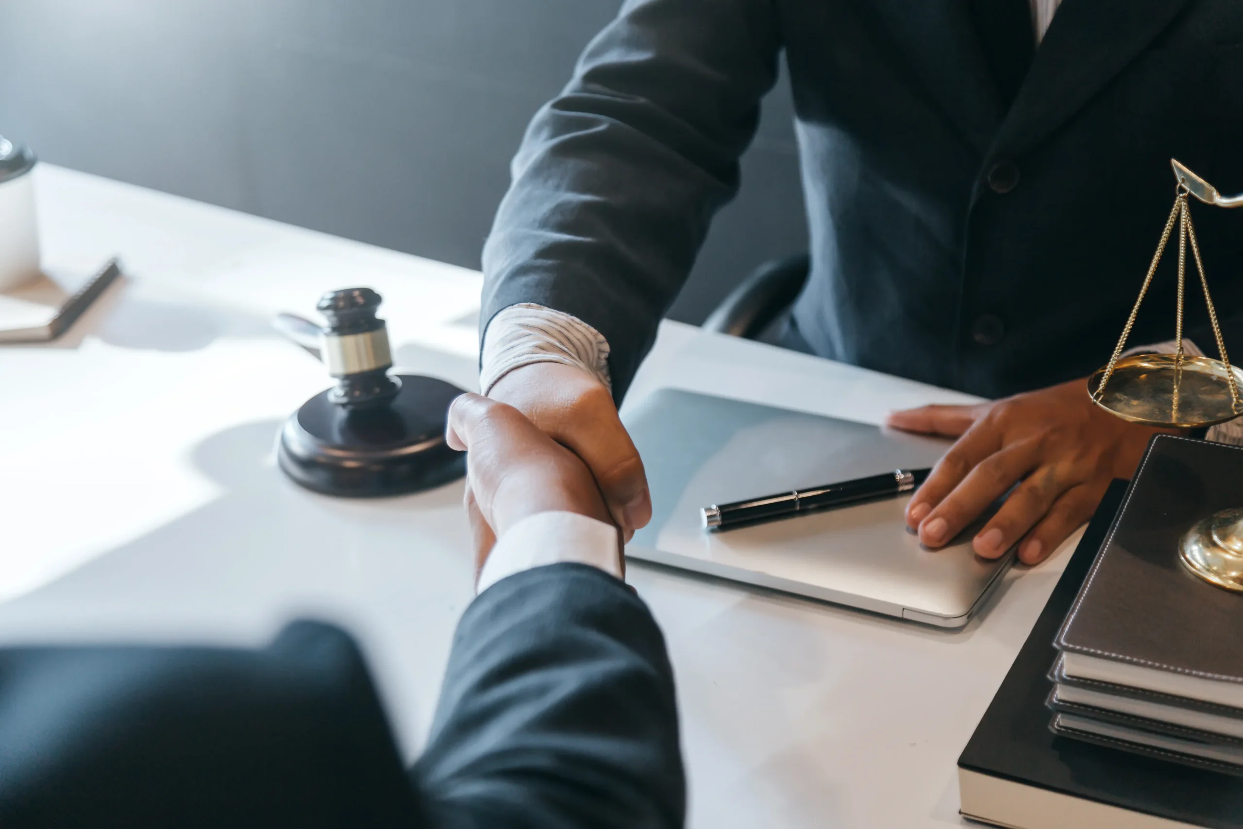 Lawyer stamping a document at a desk with a brass scale of justice nearby